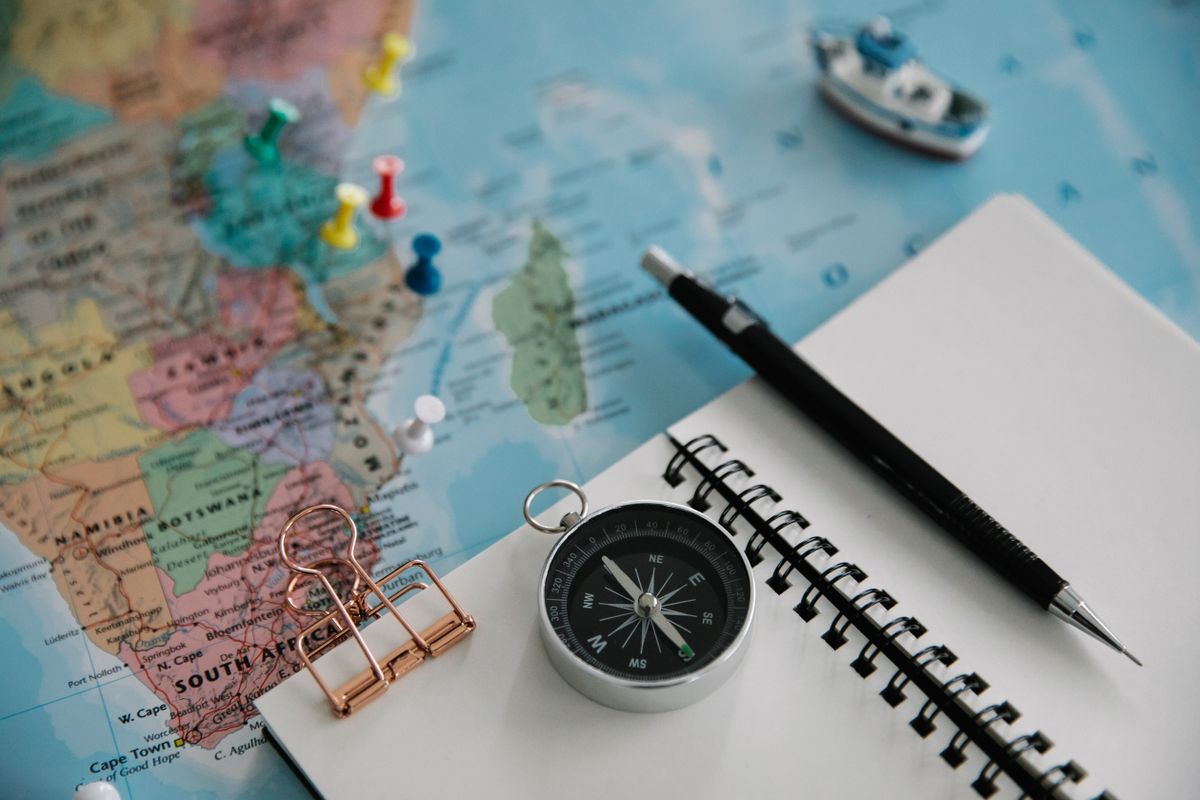 Carnet, carte et boussole pour planifier un voyage